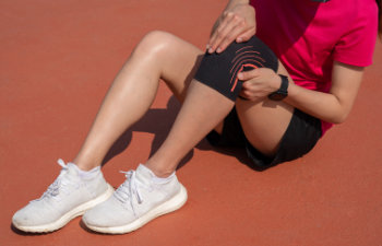 woman with leg pain in sports shoes